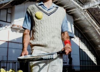tennis player bouncing the ball on a racket