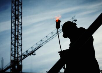 silhouette of man holding flamethrower
