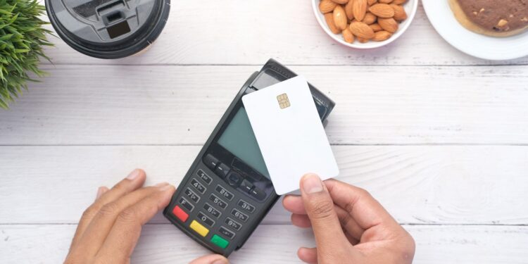 a person holding a credit card next to a calculator