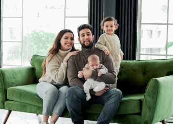 a family sitting on a green couch in a living room