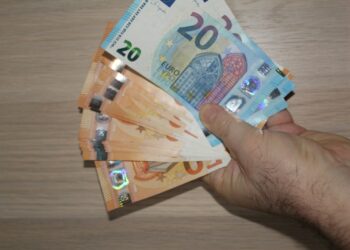 A person holding a bunch of money in their hand