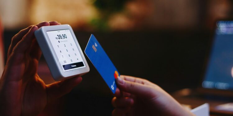 a person holding a credit card and a cell phone