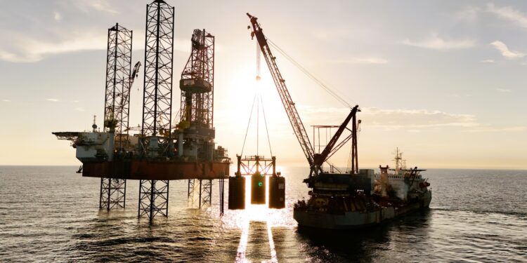 An oil rig being serviced by a supply ship.