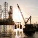 An oil rig being serviced by a supply ship.