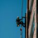 man hanging by side of building