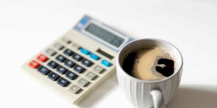 a cup of coffee next to a calculator