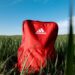 orange adidas backpack on grass field