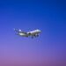commercial plane flying in clear blue sky
